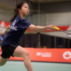 Badminton player lunges for bird