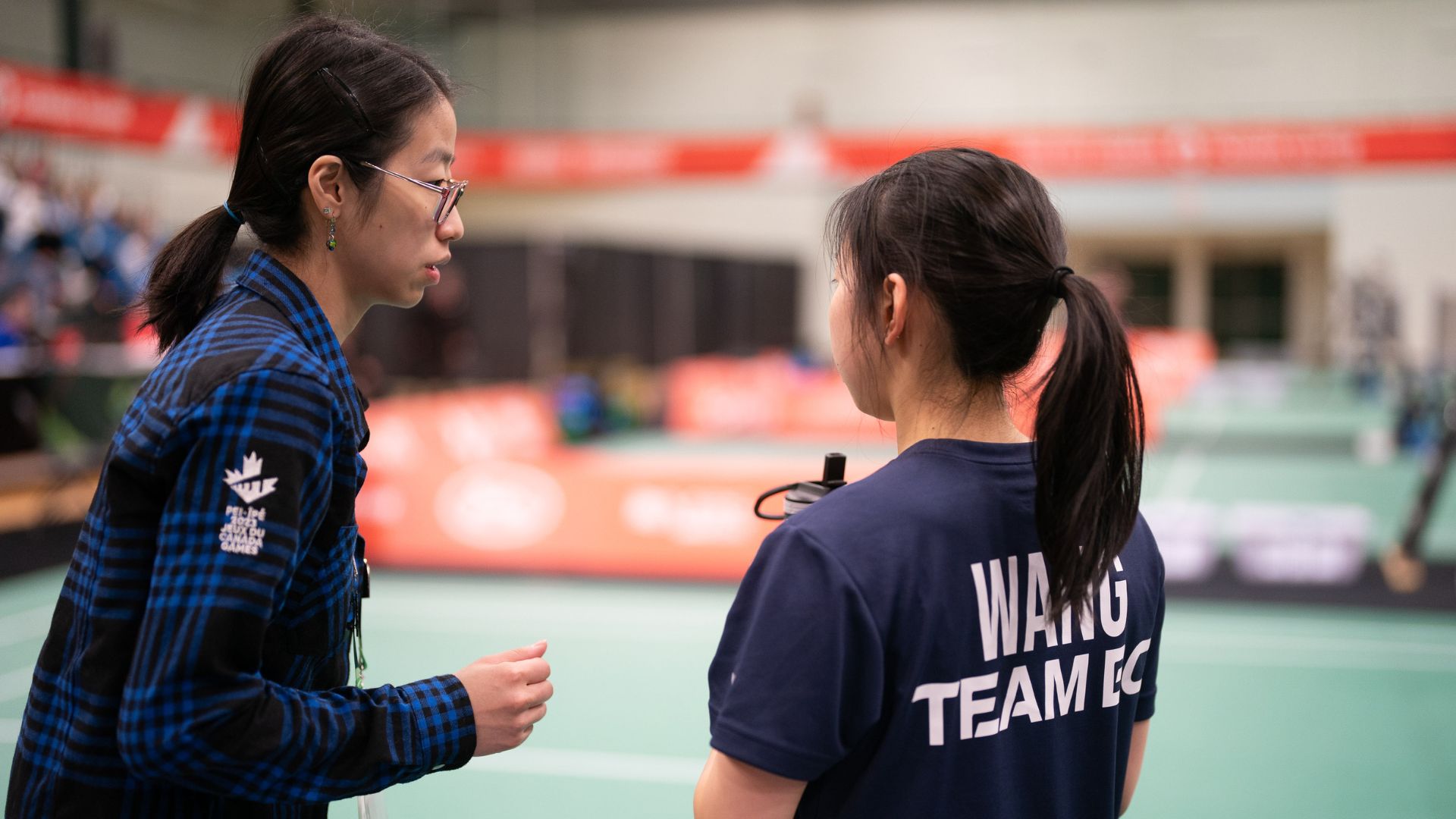 Badminton coach chats with player.