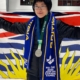 Figure skater poses with BC flag and silver medal