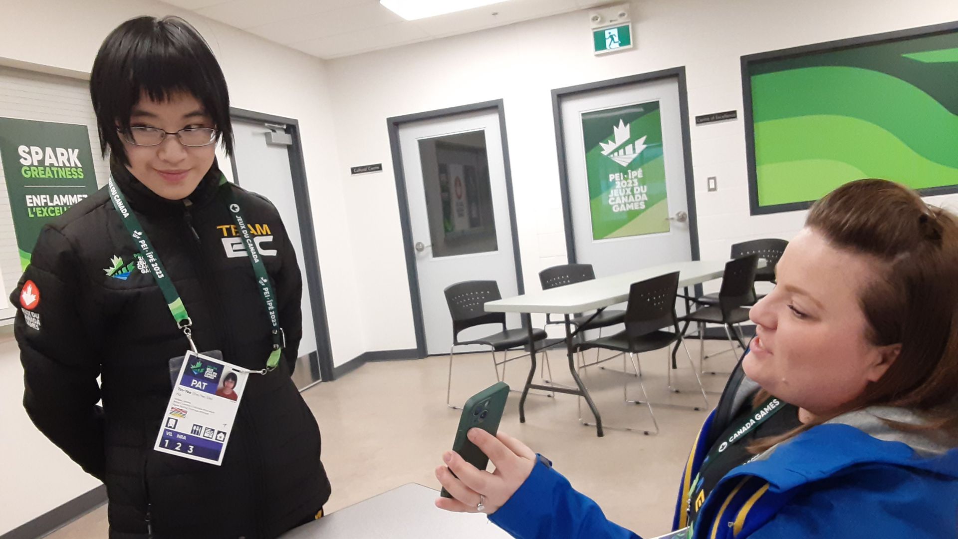 Figure skater smiles while being shown the final standings on a phone