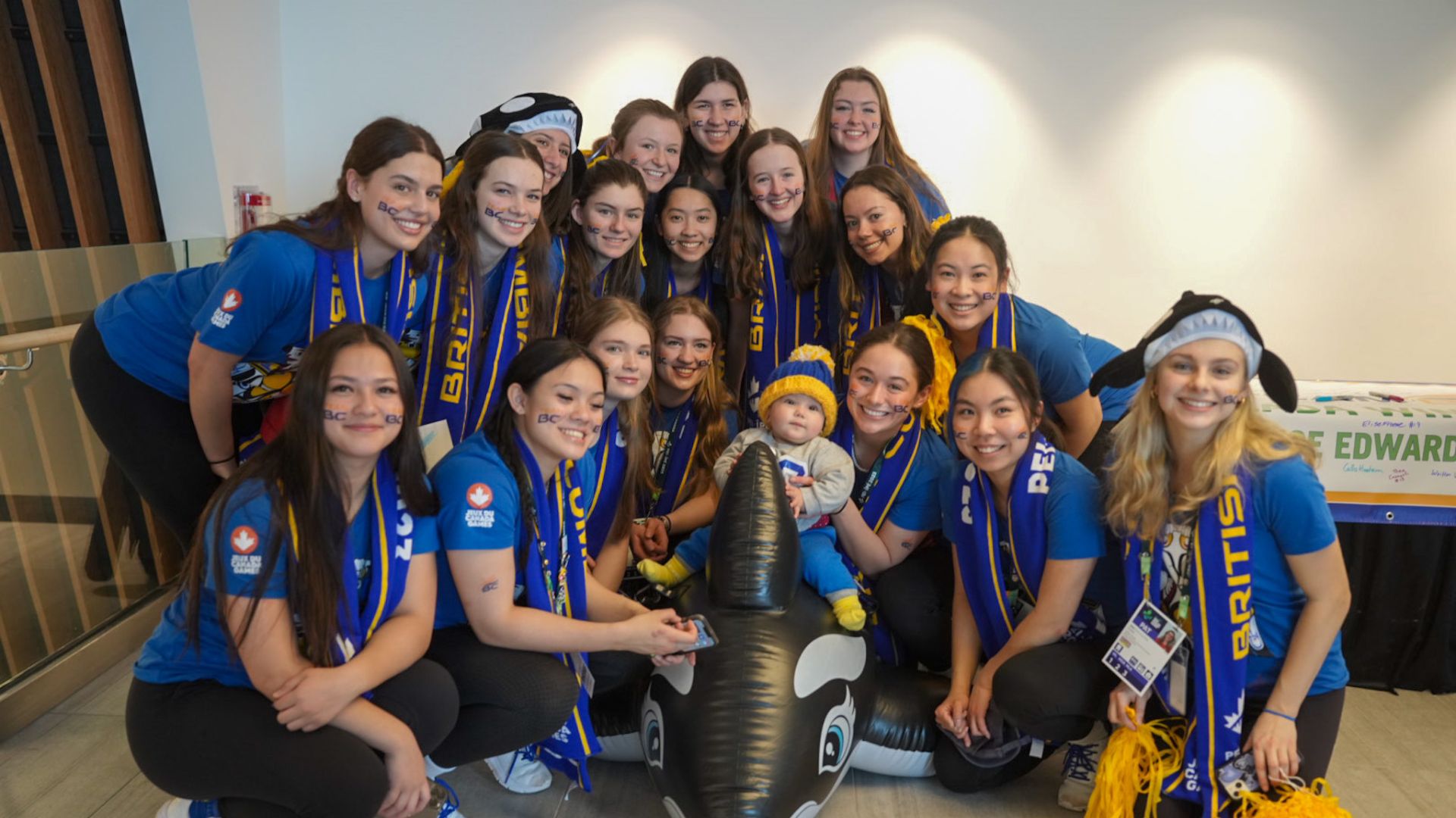 Ringette team poses with baby at the Week 1 Pep Rally.